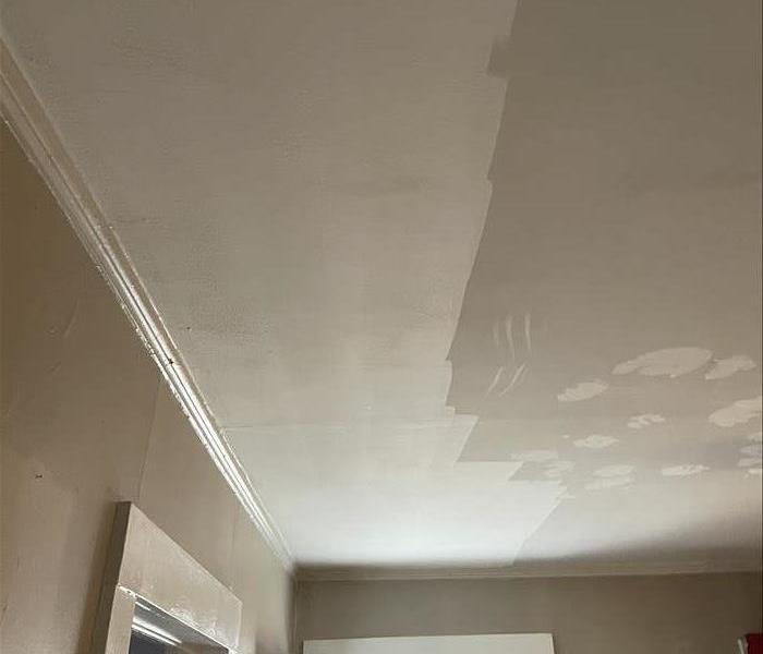 A ceiling being cleaned with dry sponges to remove soot.