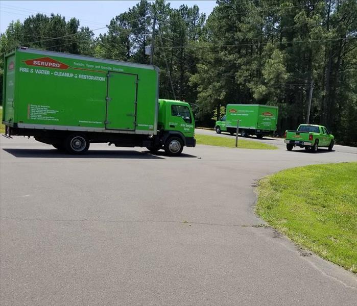 Multiple green SERVPRO vehicles leaving for a job