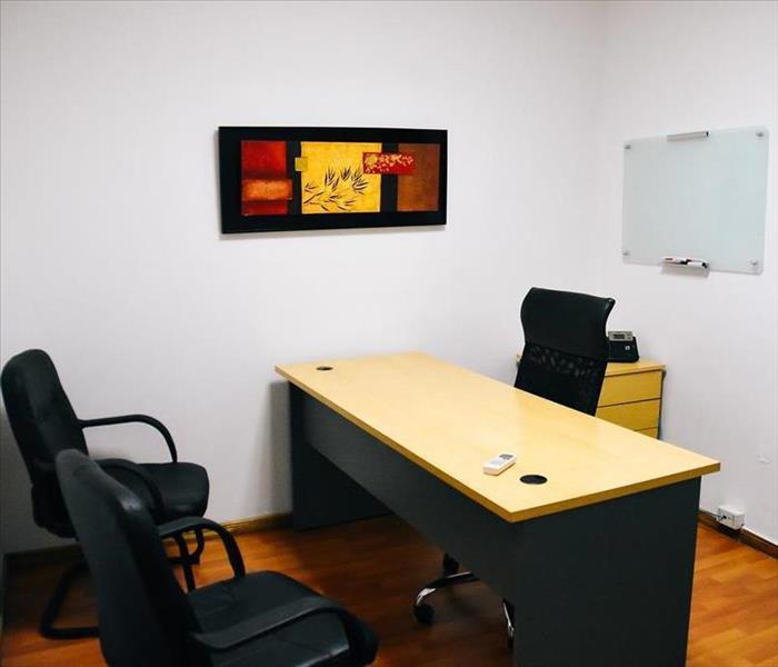 Office space shown with desk and chairs.